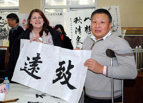 12月1日,殘疾人書法家岳英杰(右)向外國朋友贈送自己的書法作品。在今年12月3日第19個“國際殘疾人日”即將到來之際,北京市西城區(qū)舉辦以“跨越國界,攜手同行”為主題的“國際殘疾人日”主題紀念活動。外國友人走進西城區(qū)殘疾人綜合服務中心、什剎海街道殘疾人溫馨家園等殘疾人康復、學習及培訓場所,參觀殘疾人服務設施,觀看殘疾人手工制作和文體活動展示,中外朋友在“國際殘疾人日”主題紀念活動中,表達對世界各國殘疾人朋友的美好祝福。新華社記者 張旭 攝