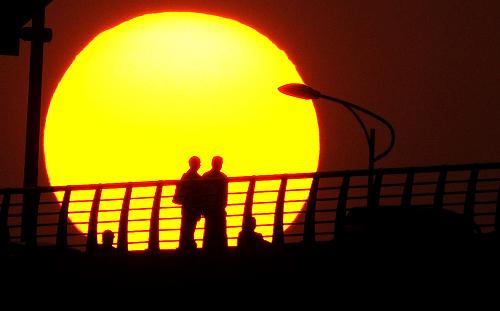 夕陽西下,廣西柳州市民在紅光大橋上漫步(2008年11月9日攝)。新華社記者 黃孝邦 攝