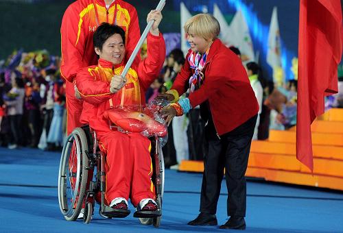 12月12日,一位母親(右)為中國代表團旗手、輪椅劍客胡道亮(中)送上亞殘運會吉祥物。來自亞洲國家和地區(qū)的殘疾人運動員的母親和中國各地300多名殘疾孩子母親組成的“母親團”在開幕式上為自己的孩子加油。當日,廣州2010年亞洲殘疾人運動會開幕式在廣州廣東奧林匹克體育中心舉行。新華社記者 劉大偉 攝