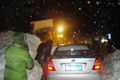 12月15日凌晨,救援人員利用大型機(jī)械清除積雪,打通救援道路。新華社發(fā)(張伯東 攝)