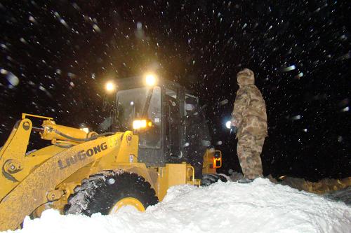 12月15日凌晨,救援人員利用大型機(jī)械清除積雪,打通救援道路。新華社發(fā)(張伯東 攝)
