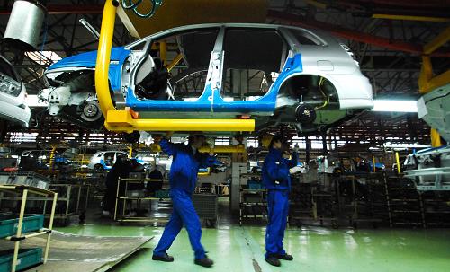 12月14日,在江西九江昌河鈴木汽車有限公司,工人們?cè)诮M裝汽車。新華社發(fā)(胡國(guó)林 攝)