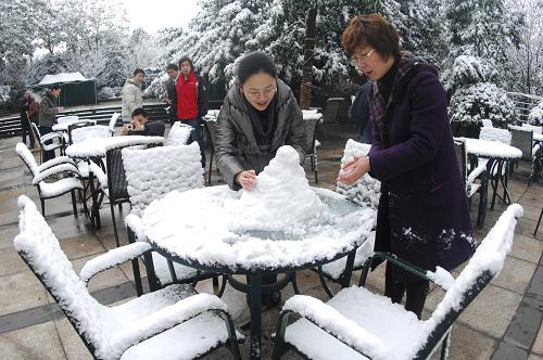 12月16日,重慶市南岸區(qū)南山,市民在堆雪人。新華社記者 陳誠 攝