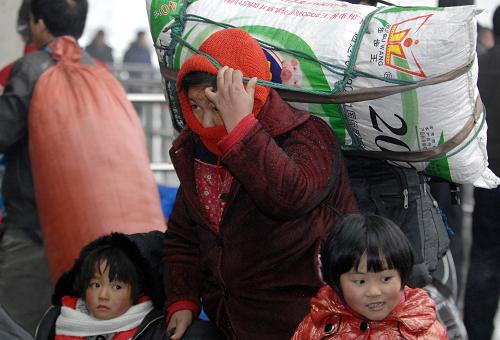 1月19日,一位外來務(wù)工者帶著小孩來到杭州汽車北站乘車出行。新華社記者 鞠煥宗 攝