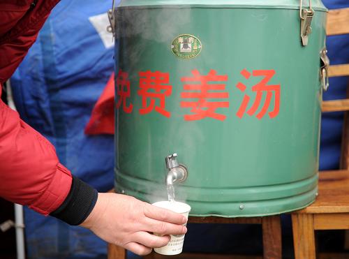 臨時救助點(diǎn)為旅客免費(fèi)提供姜湯(1月21日攝)。1月20日晚開始,江西九江市潯陽區(qū)白水湖街道在九江長江大橋入口處設(shè)立臨時救助點(diǎn),為受路面積雪、結(jié)冰影響而滯留的司機(jī)和乘客免費(fèi)提供方便面、礦泉水和餅干等。新華社記者 周科 攝