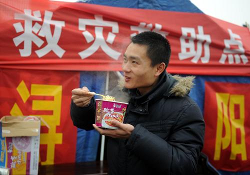 1月20日晚開始,江西九江市潯陽區(qū)白水湖街道在九江長江大橋入口處設(shè)立臨時救助點(diǎn),為受路面積雪、結(jié)冰影響而滯留的司機(jī)和乘客免費(fèi)提供方便面、礦泉水和餅干等。新華社記者 周科 攝