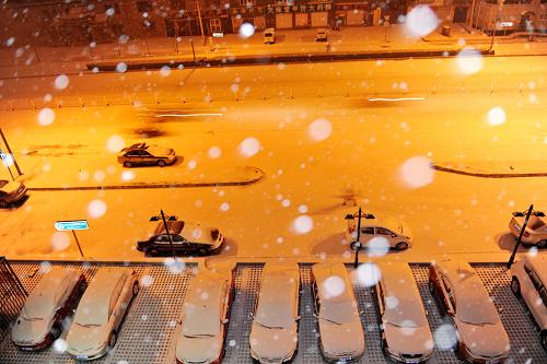 2月10日清晨,行人和車輛在北京街頭冒雪前行。當日凌晨,北京降下60年最晚初雪。新華社記者 馬寧 攝