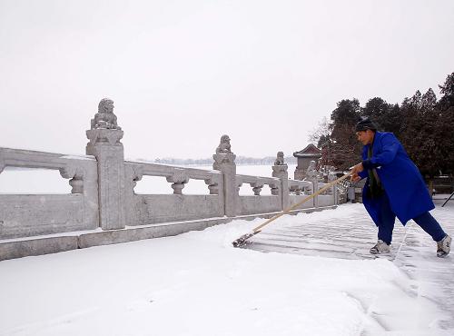 2月10日,北京頤和園管理處的職工在頤和園十七孔橋上清理積雪。2月9日深夜,北京迎來60年最晚初雪。瑞雪在為京城帶來美麗景致的同時,也給市民出行帶來不便,社會各界積極行動、迅速除雪,確保百姓出行安全。新華社記者 陳建力 攝