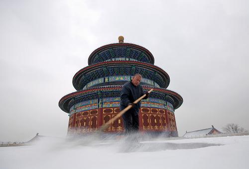 2月10日,一名工作人員在北京天壇公園祈年殿前清掃積雪。新華社記者 沈伯韓 攝