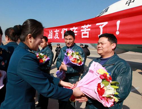 3月4日,空軍女戰(zhàn)士為長途跋涉的機(jī)組人員獻(xiàn)花。新華社記者 查春明 攝