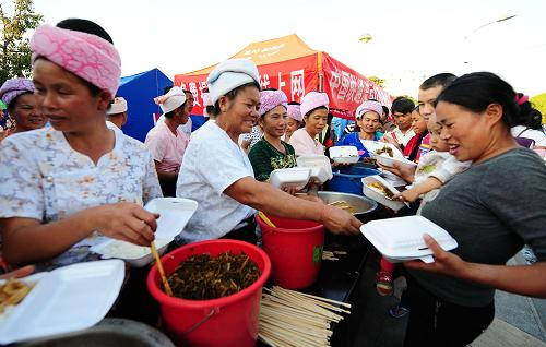 3月13日,傣族大媽們在盈湖公園安置點給受災群眾分發(fā)飯菜。新華社記者 秦晴 攝