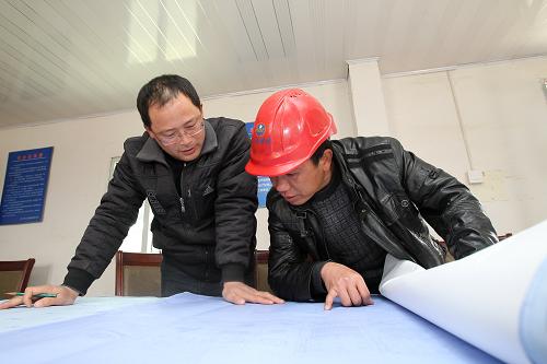 3月23日,在江蘇海門開發(fā)區(qū)一服務(wù)業(yè)項目建設(shè)工地,施志飛(左)和工作人員在查看施工圖紙。新華社發(fā)(許叢軍 攝)