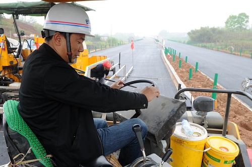 4月14日,公路建設(shè)者在績黃高速工程施工現(xiàn)場進(jìn)行路面瀝青攤鋪。新華社記者 王雷 攝