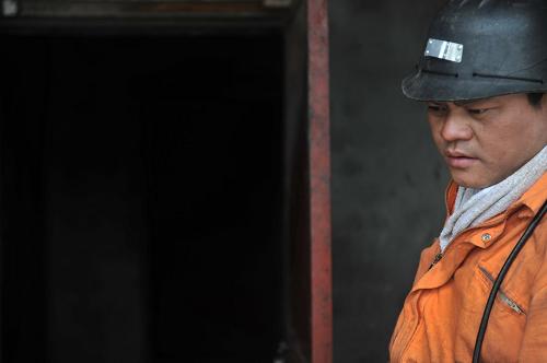 4月25日,一名救援人員站在事故煤礦井口前。新華社記者 歐東衢 攝
