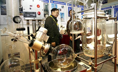 4月25日,在北京展覽館舉行的中國(guó)國(guó)際科學(xué)儀器及實(shí)驗(yàn)室裝備展覽會(huì)上,參展商向觀眾介紹“旋轉(zhuǎn)蒸發(fā)器”。新華社發(fā)(趙冰 攝)