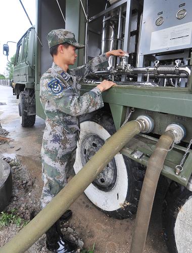6月15日晨,一名戰(zhàn)士在操作凈水車,這種野戰(zhàn)凈水車每小時可產(chǎn)生5噸生活用水、4噸飲用水。新華社記者 程敏 攝