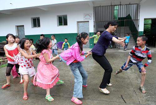 6月14日,在江西武寧縣清江鄉(xiāng)漢橋村小學(xué),孩子們和老師在做游戲。當(dāng)日,因連日暴雨被迫停課兩天的江西省武寧縣清江鄉(xiāng)650余名中小學(xué)生全部恢復(fù)上課。新華社發(fā)(蔣德先 攝)