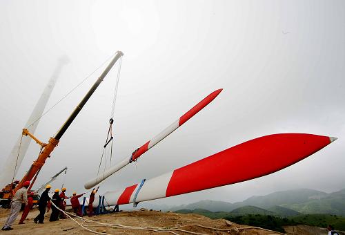 7月6日,在廣西資源縣金紫山風電場,工人們起吊風力發(fā)電機組葉片進行組裝。地處廣西桂林北部山區(qū)的資源縣風力資源豐富,尤其是位于金紫山海拔1300米以上的區(qū)域地形開闊極具風電開發(fā)價值。正在建設中的金紫山風電場是一個集生態(tài)、環(huán)保、清潔于一體的重點能源項目。一期工程總裝機容量49.5兆瓦,安裝33臺1500千瓦的風力發(fā)電機組,年上網發(fā)電量9500多萬千瓦時。目前,工人們正冒著酷暑進行風電場風機裝機工作,預計8月底可投產。新華社發(fā)(鄧華 攝)