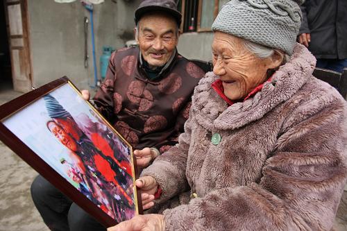2月14日,楊志昌(左)與老伴楊淑芝一起欣賞記者去年給他們拍攝的照片。當(dāng)日是情人節(jié),在四川眉山市仁壽縣慈航鎮(zhèn)大塘村,104歲的楊志昌與101歲的老伴楊淑芝一起歡度這個(gè)特別的節(jié)日。兩位老人已相伴82年,是眉山市目前唯一一對(duì)百歲夫妻。1930年,22歲的楊志昌經(jīng)父母包辦,娶了同村比他小3歲的楊淑芝為妻。入洞房時(shí),兩人才偷偷瞄了對(duì)方一眼,沒想到一見鐘情,此后相伴一生。新華社發(fā)(姚永亮 攝)
