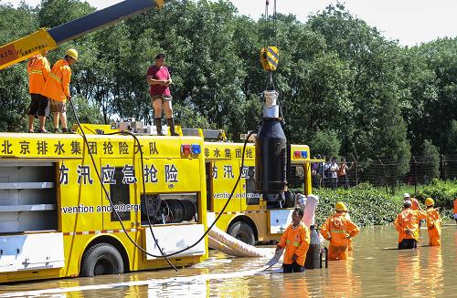 7月22日,北京市排水集團(tuán)搶險人員正在進(jìn)行搶險。記者從北京消防部門了解到,21日的強(qiáng)降水導(dǎo)致京港澳高速公路16公里處一鐵路橋下嚴(yán)重積水,導(dǎo)致多臺車輛被淹,22日上午已發(fā)現(xiàn)3名遇難者的遺體。由于積水量大,作業(yè)時間長,北京市交通部門預(yù)計23日京港澳高速仍然無法通行。新華社記者 張宇 攝