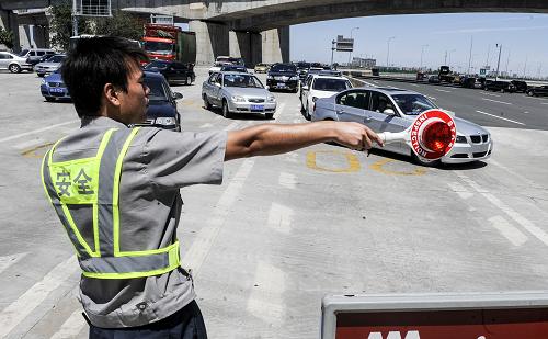 7月22日,在京港澳高速公路杜家坎收費(fèi)站,工作人員引導(dǎo)車輛排隊掉頭。新華社記者 張宇 攝