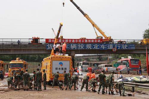 7月23日,參與救援工作的武警北京總隊(duì)某部官兵在進(jìn)行清理淤泥工作。 新華社發(fā)(李光印 攝)