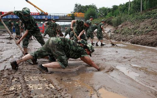 7月23日,參與救援工作的武警北京總隊(duì)某部官兵在進(jìn)行清理淤泥工作。 新華社發(fā)(李光印 攝)
