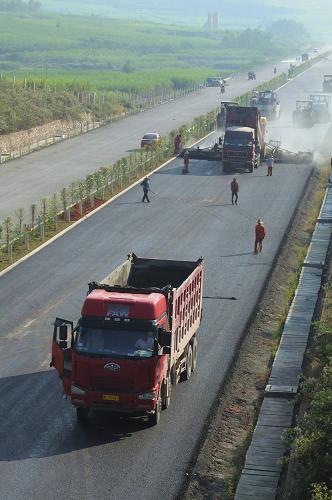 10月22日,在廣西欽崇高速公路上思縣路段,工人在鋪設瀝青路面。新華社發(fā)(梁富盈 攝)
