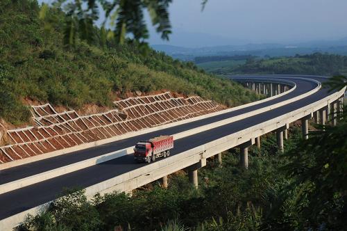 10月22日,在廣西欽崇高速公路上思縣路段,一輛施工車輛行駛在掃火山大橋上。掃火山大橋是欽崇高速公路的最長橋梁,長度約720米。新華社發(fā)(梁富盈 攝)