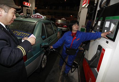4月7日零時(shí)許,上海一位出租車司機(jī)(左)正在加油站內(nèi)為車輛加油。當(dāng)日零時(shí)起,國(guó)內(nèi)汽、柴油最高零售限價(jià)價(jià)格分別上漲每噸500元和400元。此次調(diào)價(jià)之后,上海地區(qū)加油站93號(hào)汽油每升7.79元,97號(hào)汽油每升8.29元。新華社記者 裴鑫 攝