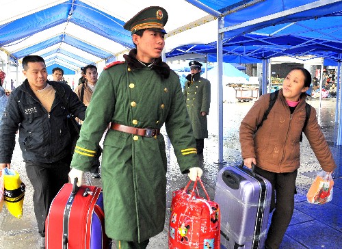 1月29日,在廣州火車站值勤的武警戰(zhàn)士主動幫助有困難的旅客上車。新華社記者陳學(xué)思攝