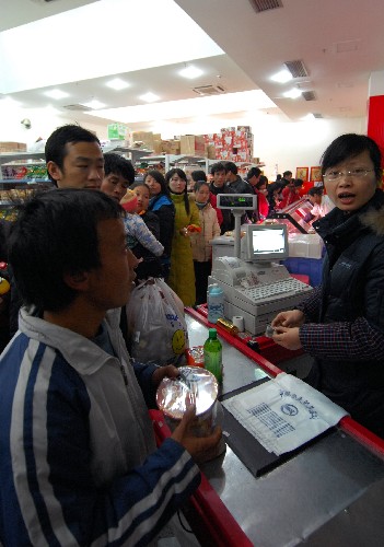2月1日,旅客在江西長(zhǎng)運(yùn)股份有限公司南昌長(zhǎng)途汽車站超市排隊(duì)購(gòu)買食品。新華社發(fā)(周科攝)