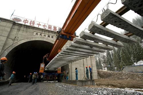 精伊霍鐵路鋪軌到伊犁河谷 3月31日,在新疆尼勒克縣境內(nèi)的精伊霍鐵路北天山隧道出口,鋪軌機正將一節(jié)軌排放置到隧道外的路基上,這標志著精伊霍鐵路已鋪軌到伊犁河谷。 精伊霍鐵路(精河-伊寧-霍爾果斯口岸)是國家重點建設工程,也是新疆首條電氣化鐵路,起于烏魯木齊至阿拉山口鐵路的精河站,穿過北天山主嶺,經(jīng)伊犁到達終點霍爾果斯口岸,全長285公里。目前,鋪軌按期通過北天山隧道,隨后將經(jīng)伊犁直奔霍爾果斯,并有望于今年年底建成。 新華社發(fā)(劉成剛 攝)
