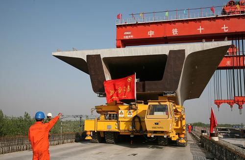 4月18日,京滬高速鐵路廣陽(yáng)制梁場(chǎng)附近,中國(guó)鐵建十七局集團(tuán)的巨型運(yùn)梁車正將一片重達(dá)900噸的箱梁運(yùn)往前方架梁作業(yè)現(xiàn)場(chǎng)。 京滬高速鐵路自2008年4月18日開(kāi)工建設(shè)一周年之際,鐵路建設(shè)首戰(zhàn)告捷,攻堅(jiān)之戰(zhàn)全面展開(kāi),形勢(shì)十分喜人。 新華社發(fā)(劉渝攝)