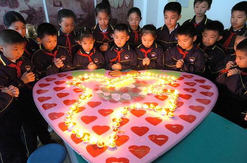 5月11日,濟南市大明湖小學的同學們圍繞在親手制作的祝福卡前,為災區(qū)小朋友祈愿。 新華社發(fā)
