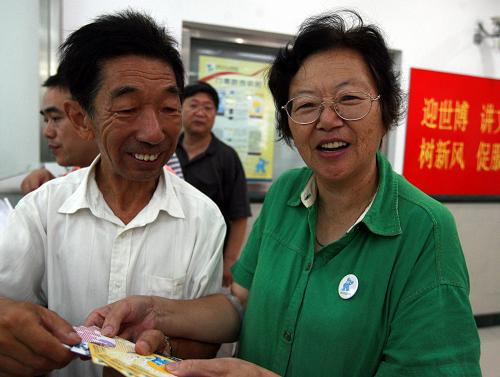 7月1日早晨,家住浦東的孔芝芳和老伴來到中國郵政浦東臨沂支局為在臺灣的親戚購買上海世博會個人門票。新華社記者 任瓏 攝