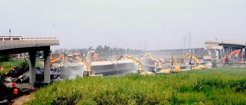 7月15日拍攝的津晉高速公路匝道橋坍塌事故現(xiàn)場。當(dāng)日凌晨1時33分,津晉高速公路港塘收費站800米外匝道橋坍塌,5輛載貨車墜落,造成6人死亡,4人受傷。天津市各相關(guān)部門迅速趕到現(xiàn)場實施救援清理。事故原因正在調(diào)查中。新華社發(fā)(王喜南 攝)