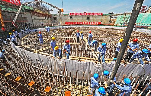 7月17日,工人們?cè)跒榍厣胶穗娬緮U(kuò)建工程2號(hào)機(jī)組核反應(yīng)堆廠(chǎng)房基礎(chǔ)澆注第一批混凝土。新華社記者 譚進(jìn) 攝