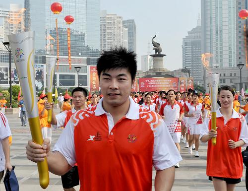 9月4日,北京奧運(yùn)會(huì)舉重冠軍陸永(前)手持火炬進(jìn)行傳遞。當(dāng)日,第十一屆全運(yùn)會(huì)火炬在廣西南寧市傳遞。 新華社記者周華攝