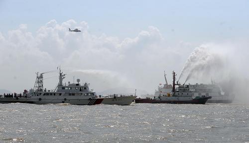 9月4日,救援船只為客輪滅火。 當(dāng)日,“多部委、海陸空、北京、杭州、寧波”三地同步進(jìn)行、我國(guó)有史以來(lái)最大規(guī)模海上演習(xí)——2009年國(guó)家海上搜救桌面演習(xí)暨東海搜救演習(xí)成功舉行。 一艘載有368名旅客、22名船員的客滾船“寧舟”輪在寧波—舟山核心港區(qū)佛渡水道海域因主機(jī)故障,與散裝化學(xué)船“岱河”輪發(fā)生碰撞。“寧舟”輪數(shù)百名人員及沿岸數(shù)萬(wàn)居民的生命受到嚴(yán)重威脅。中國(guó)海上搜救中心立即成立總指揮部,通知工信部、公安部、民政部、農(nóng)業(yè)部、衛(wèi)生部、海關(guān)總署、安監(jiān)總局、地震局、氣象局、海洋局、民航局、總參、海軍、空軍、武警部隊(duì)等成員單位按其職責(zé)啟動(dòng)應(yīng)急聯(lián)動(dòng)響應(yīng)預(yù)案,并成立協(xié)調(diào)指揮部。在總指揮部的統(tǒng)一組織協(xié)調(diào)下,一場(chǎng)聲勢(shì)浩大的“海、陸、空”立體搜救迅速展開(kāi)。這次演習(xí)呈現(xiàn)出“多部委參與、演習(xí)科目?jī)?nèi)容豐富、指揮層次多和技術(shù)保障要求高”的特點(diǎn)。在演習(xí)科目、指揮層次和技術(shù)保障等方面為歷屆演習(xí)之最。 新華社記者 徐昱攝