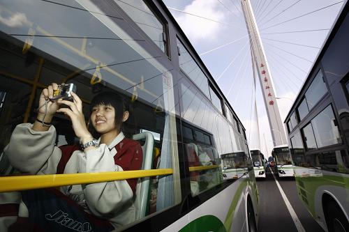 10月31日,一位市民正在公交車上拍攝上海長江大橋。新華社記者 裴鑫 攝