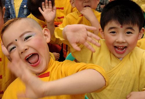 2005年3月31日,在烏魯木齊市東方花園,兩位小朋友在給表演節(jié)目的同班同學(xué)加油助威。新華社發(fā)(楊萬江攝)