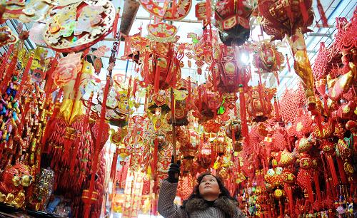 1月12日,南昌市西湖區(qū)萬壽宮商城一家店鋪工作人員掛出新年飾物。新華社記者 周科 攝