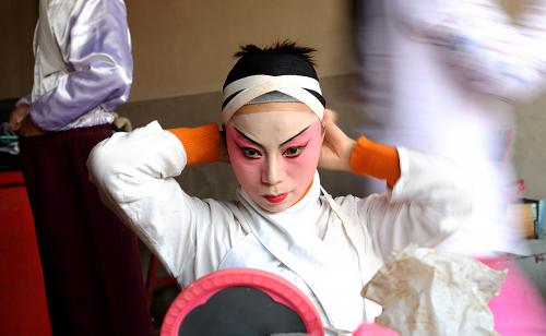 福建省莆田市仙游縣莆仙戲?qū)I(yè)劇團——鯉聲劇團的演員在演出前化妝(1月14日攝)。新華社記者 姜克紅 攝