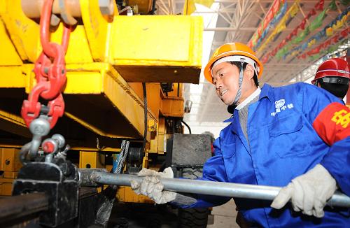 1月26日,中鐵二局的建設(shè)者在成都至都江堰鐵路青城山車站準(zhǔn)備進(jìn)行最后鋪軌。新華社記者 陳凱 攝