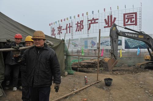 1月26日,幾名建筑工人從北京什邡產(chǎn)業(yè)園建筑工地走過(guò)。新華社記者 魯鵬 攝