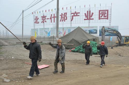 1月26日,幾名建筑工人從北京什邡產(chǎn)業(yè)園建筑工地走過(guò)。新華社記者 魯鵬 攝