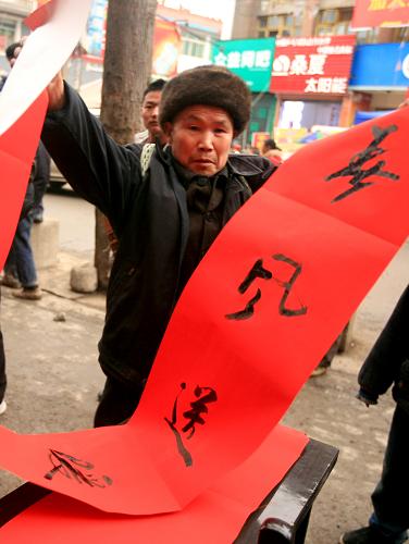 2月1日,湖北利川市汪營(yíng)鎮(zhèn)老鄉(xiāng)在集鎮(zhèn)上領(lǐng)取春聯(lián)。新華社發(fā)(田代明 攝)