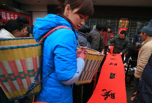 2月1日,湖北利川市汪營(yíng)鎮(zhèn)老鄉(xiāng)在集鎮(zhèn)上領(lǐng)取春聯(lián)。新華社發(fā)(田代明 攝)