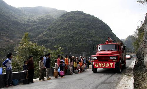 2月1日,廣西大化瑤族自治縣組織抗旱送水車為七百弄鄉(xiāng)弄魯屯群眾送水。2009年8月以來,廣西壯族自治區(qū)遭遇秋冬連旱,據(jù)自治區(qū)防汛抗旱指揮部新近統(tǒng)計(jì),目前大約還有24萬多人、11萬頭大牲畜面臨飲水困難。目前,廣西各地政府已派出大批干部下鄉(xiāng),及時(shí)為旱區(qū)群眾提供應(yīng)急供水。同時(shí),廣西正在進(jìn)行新一輪大規(guī)模農(nóng)田水利建設(shè),以提高抵御旱災(zāi)的能力。新華社發(fā)(韋哲 攝)